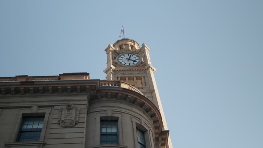 Slow motion shot of the clock tower at Central Station in Sydney, lit by the afternoon sun.