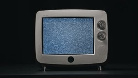 Old TV flickering screen standing table at black background closeup. White noise vibrating on retro monitor. Vintage television losted channel signal emitting distortion. CRT display flashing static. - Powered by Shutterstock - Get 15% off with code: PIKWIZARD15