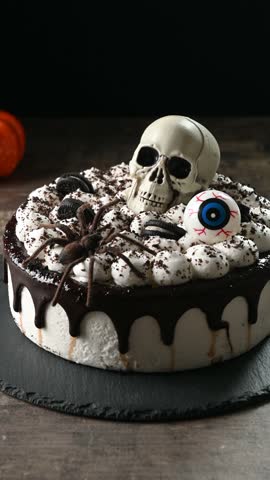 Spooky Halloween chocolate Cake with Skull, Eyeball, and Spider Decoration on dark background	
