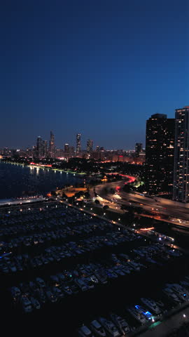 Breathtaking and Cinematic Chicago skyline illuminated at night, sparkling against the dark sky and beautifully captured from an aerial drone perspective high above the vibrant city