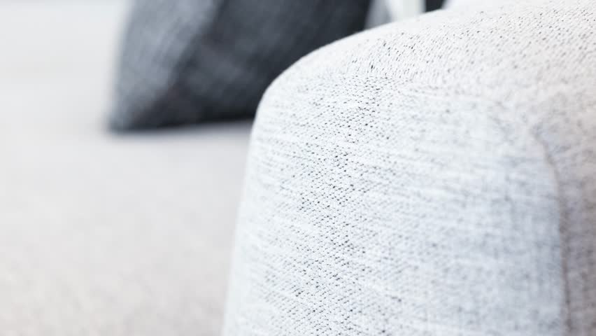 Camera glides along textured armrest as dark cushion softens the backdrop