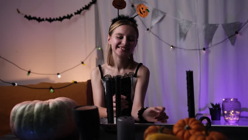 Cute Little Girl Blowing Out A Candle In A Halloween Decorated Room