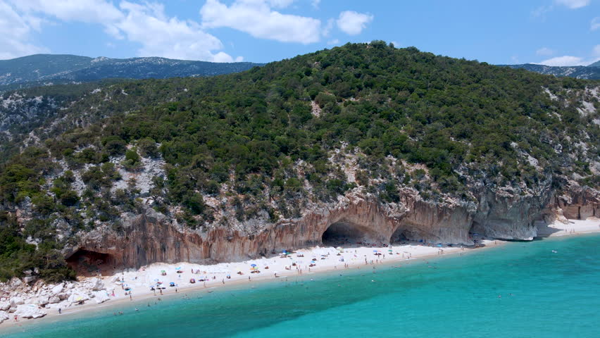 Reverse Aerial Drone Shot Revealing Caves and Sea at Cala Luna Beach – Sardinia Coastline