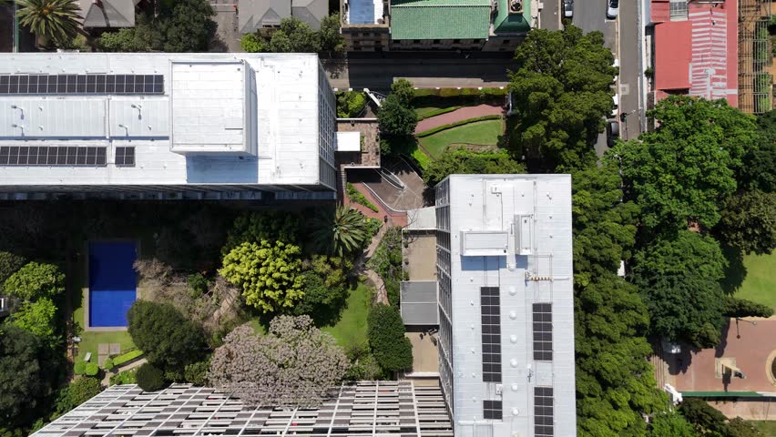 4K drone footage of central Cape Town featuring city park, dome-shaped cathedral, and surrounding buildings. Aerial view of urban architecture and public green space.