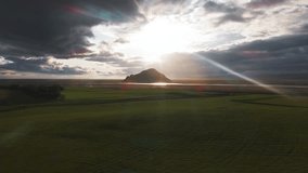 Aerial view of a solitary mountain in Iceland, surrounded by flatlands and winding rivers. The camera sweeps slowly under sunlight breaking through clouds. - Powered by Shutterstock - Get 15% off with code: PIKWIZARD15