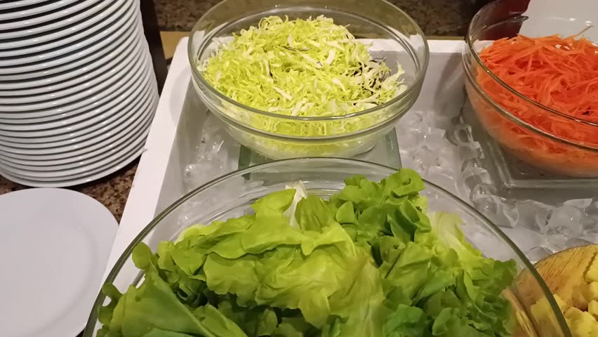 Lots of snacks, salads, grated carrots, grated cheese in glass plates in restaurants and cafes.