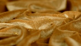 This image captures the rich texture of golden velvet fabric in a close-up shot. The fabric is draped in soft folds and wrinkles, creating a - Powered by Shutterstock - Get 15% off with code: PIKWIZARD15