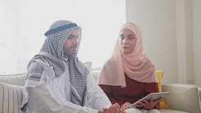 Muslim couple using tablet at home, modern islamic collaboration, learning or planning, concept of faith, family and technology online shopping, e-commerce platform, arab culture, islamic fintech - Powered by Shutterstock - Get 15% off with code: PIKWIZARD15