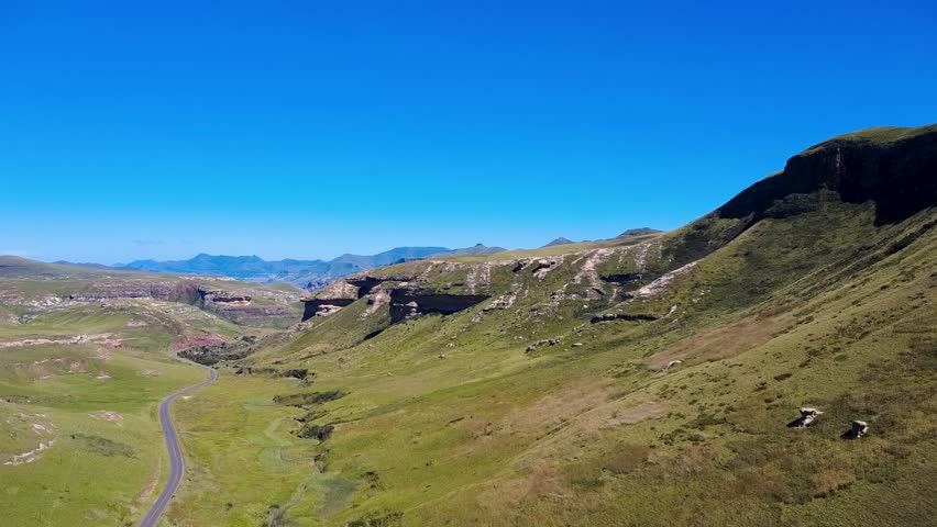 Revealing drone shot of a winding road through a hilly national park, showcasing scenic beauty. Perfect for nature, travel, and adventure projects.