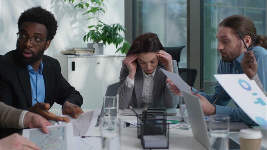 Stressed unhealthy Caucasian team leader businesswoman holding head ache headache pain suffering medicine multiethnic colleagues diversity business people arguing conflict shouting yelling in office - Powered by Shutterstock - Get 15% off with code: PIKWIZARD15