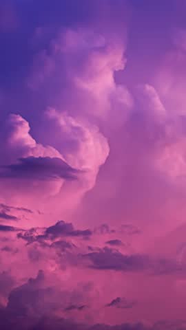 Colorful storm clouds in vivid pink and purple hues drift and swirl in a vertical timelapse shot
