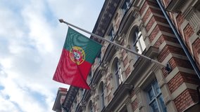 A Portuguese flag hangs outside the embassy building in Stockholm, Sweden, gently waving against a cloudy sky on a calm day - Powered by Shutterstock - Get 15% off with code: PIKWIZARD15