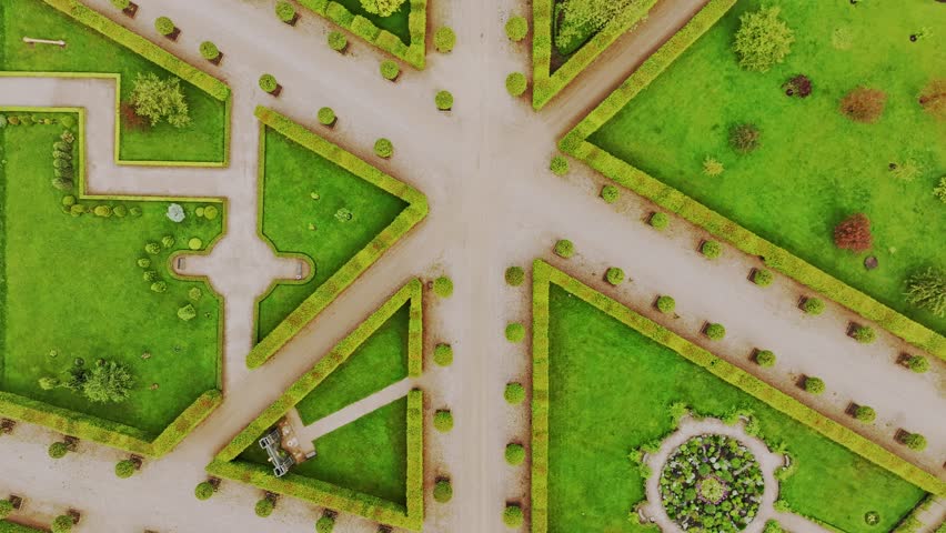 French formal garden with hedges and flower patterns, aerial backward flight