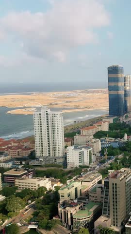 Cinematic drone footage over Colombo, Sri Lanka, capturing a vibrant mix of high-rises, ocean views, and tropical cityscape. Ideal for real estate, travel, editorial, and urban development use. 