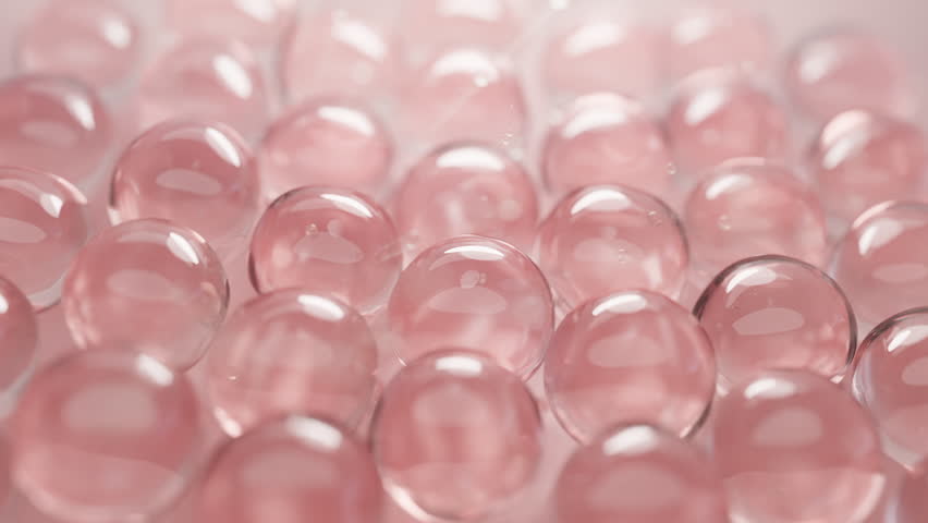 Soft pink collagen beads glistening, close-up. Perfect for skincare, beauty, anti-aging, and wellness content. Symbolizes youthful skin, pure essence, and gentle treatment.