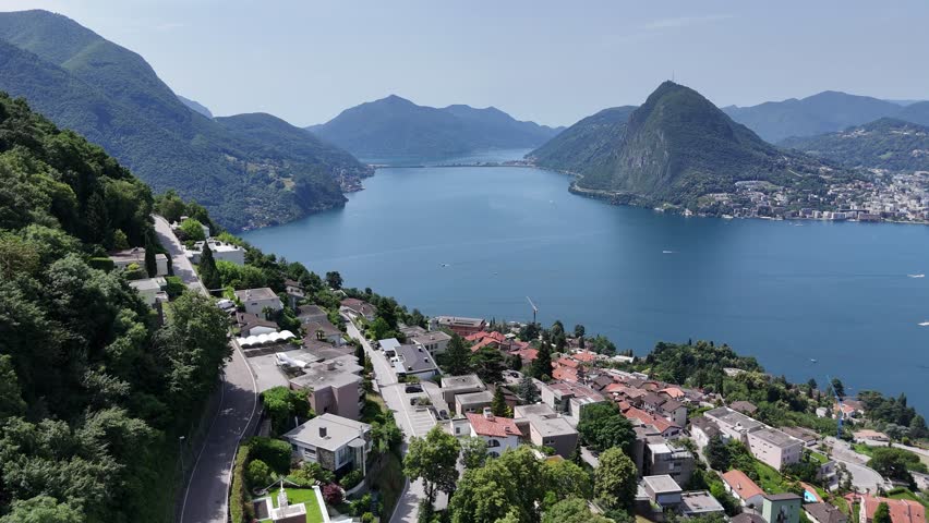 Hillside houses overlooking Lake Lugano Switzerland Panning drone aerial