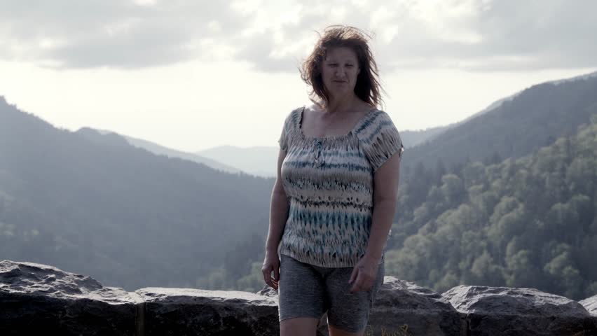 Middle aged woman turning to view overlook in the Great Smoky Mountains National Park in slow motion.