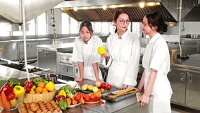 Chef instructor teaching two young culinary students in a commercial kitchen during a professional cooking class with fresh vegetables. Ideal for chef training, gastronomy, and food education themes. - Powered by Shutterstock - Get 15% off with code: PIKWIZARD15