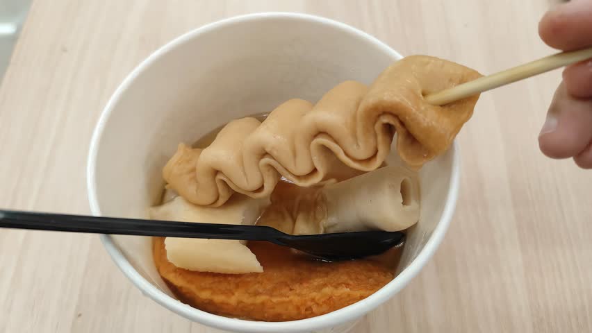 Close up Delicious Korean Fish Cake Skewer Soup in Paper Cup. A bowl of odeng. Street food korea.