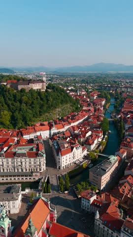 Aerial panoramic establishing of Preseren Square and iconic Triple Bridge in Ljubljana’s historic city center in Slovenia, vertical