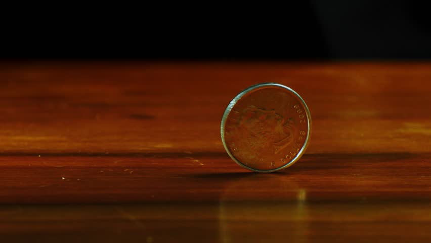 close up of one ounce maple leaf silver coin spins on the table in slow motion