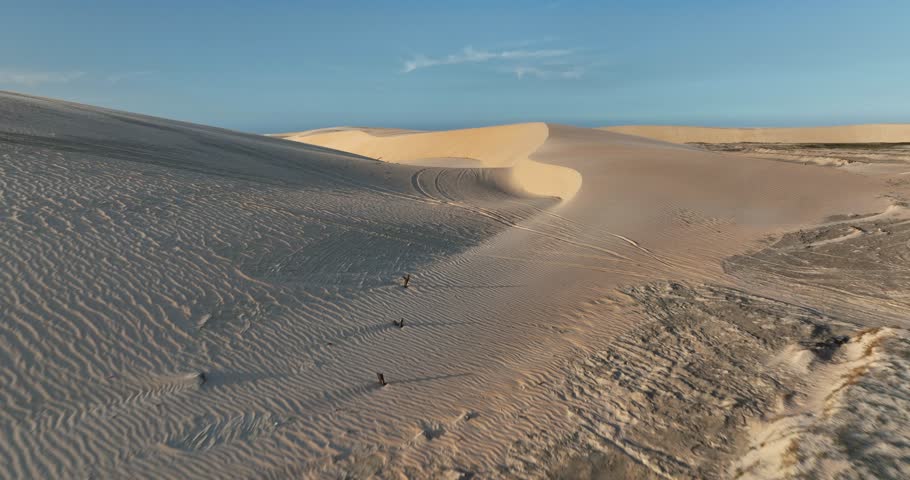 Top-down view of vast white sand dunes with scattered lagoons at Lençóis Maranhenses National Park.