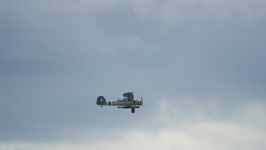 Side View of Fairey Swordfish Biplane Bomber Used During World War 2 Flying Across Sky in Slow Motion with Front Propeller. British Historical Aviation Footage.