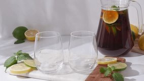 Glass cups and a jug of lemon and lime iced tea on a white table. Sunny day and sharp shadows from glass of lemonade - Powered by Shutterstock - Get 15% off with code: PIKWIZARD15