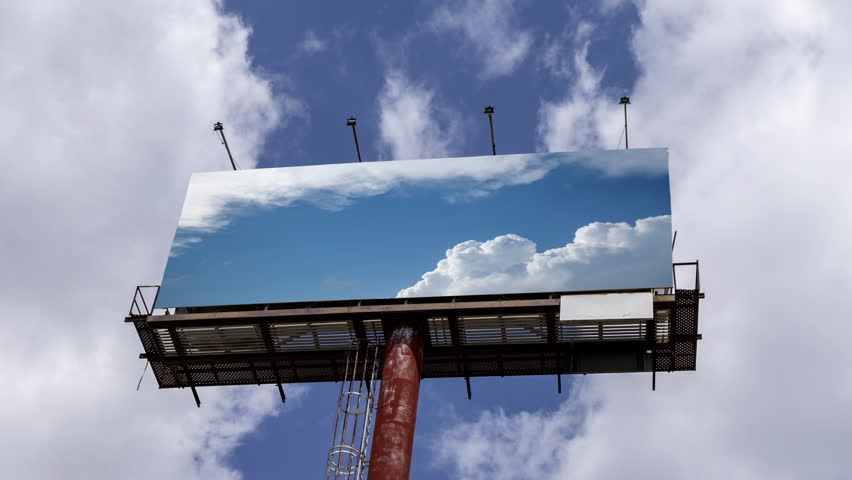large outdoor advertising bill board with clouds on the screen 