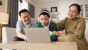 Grandparents and grandson spending quality time together at home while the elderly grandfather and grandmother support their young grandson with school homework and digital learning on a laptop - Powered by Shutterstock - Get 15% off with code: PIKWIZARD15