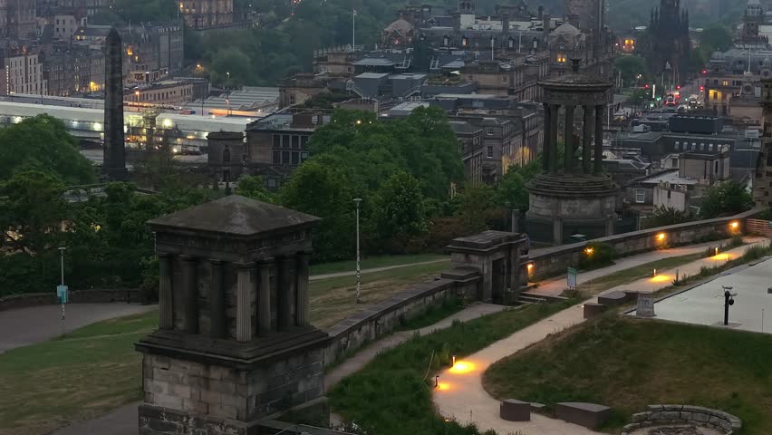 Cinematic drone reveal of Edinburgh Castle on a foggy twilight day. Atmospheric and mysterious mood with soft light, mist, and historic architecture
