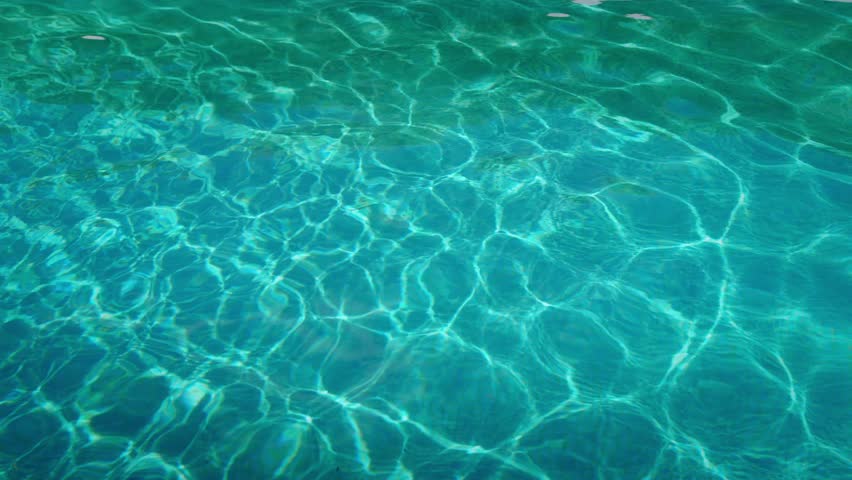 Slow motion of woman swimming underwater across pool in fixed wide shot – peaceful summer moment in 4K