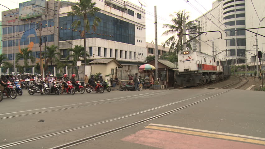 JAKARTA, INDONESIA - FEBRUARY 2013: Train passes through busy streets in