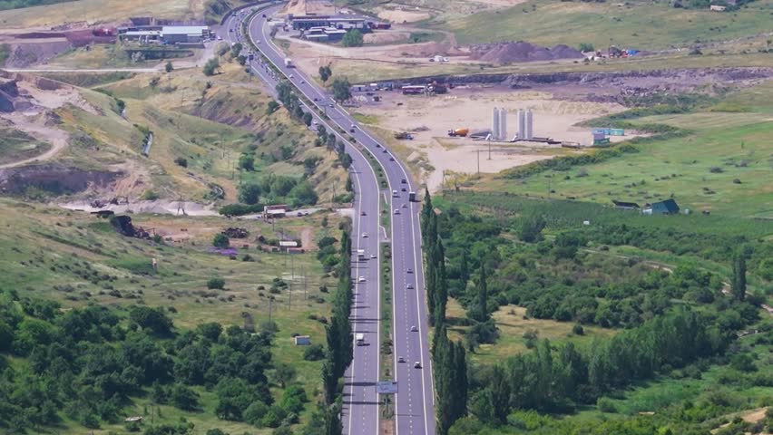 Highway traffic moving in both directions. Aerial view of highway traffic moving in both directions through the scenic landscapes of Armenia in the Caucasus region. 