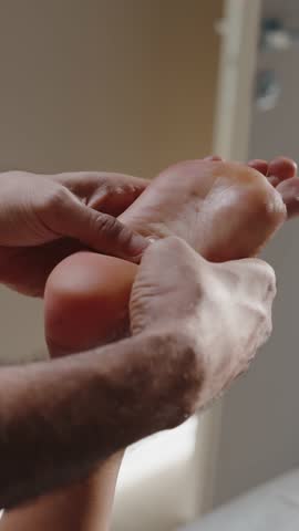 Therapist Massaging Foot with Both Hands Indoors