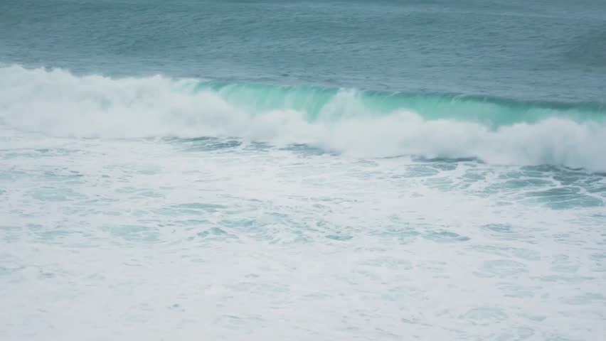 A powerful ocean wave crashing with turquoise color and foamy white crest
