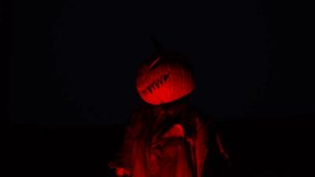 Scary scarecrow with pumpkin head slowly turns his head in a dark field. Spooky Halloween scene captured in rural landscape with haunting vibe - Powered by Shutterstock - Get 15% off with code: PIKWIZARD15