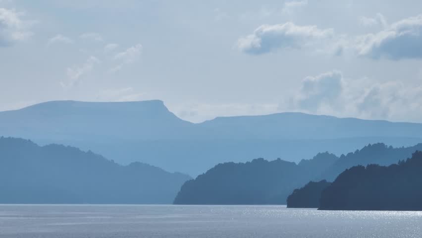 Lake Moquehue surrounded by mountains under cloudy sky. Patagonian landscape in Neuquen, Argentina