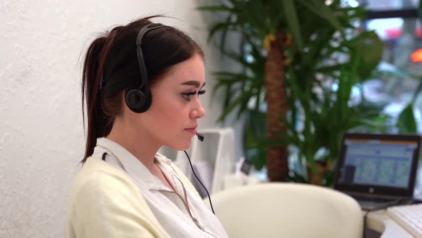 Call Center Office: Portrait of Friendly European Female Technical Customer Support Specialist Talking on a Headset, uses Computer. Client Experience Officer Helps Online via Video Conference - Powered by Shutterstock - Get 15% off with code: PIKWIZARD15
