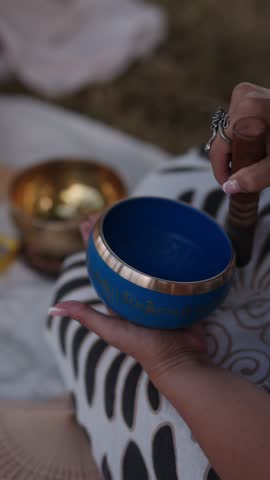 Tibetan singing bowl in the woman hands, vertical video