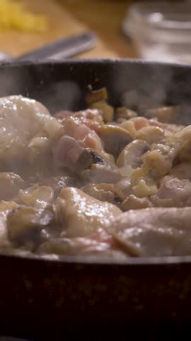 Cooking chicken and mushrooms with onions in pan on stove in kitchen enhances natural flavors. Perfect recipe idea for satisfying dinner or weekly meal plan