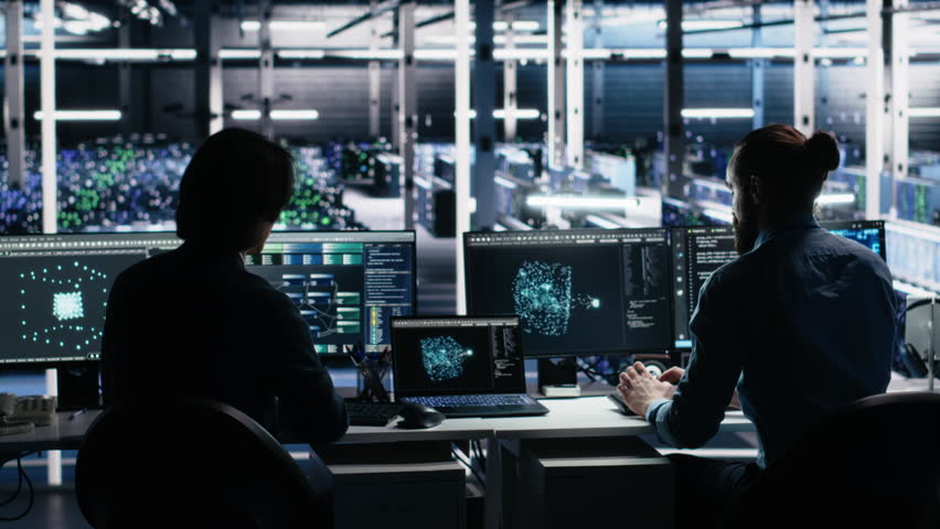Senior programmer and coworker in data center coding with generative AI assistance. Teamworking colleagues leveraging artificial intelligence large language model to solve tasks, camera A