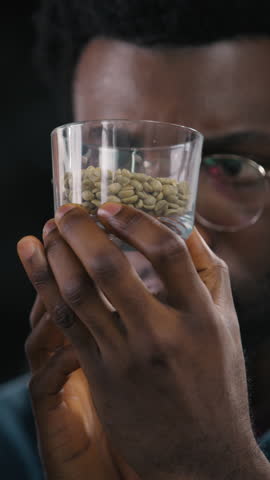 Close up African American Caucasian men inspect coffee cups study differences examine aroma texture concentration roasting quality small business flavor expertise roaster comparison factory process
