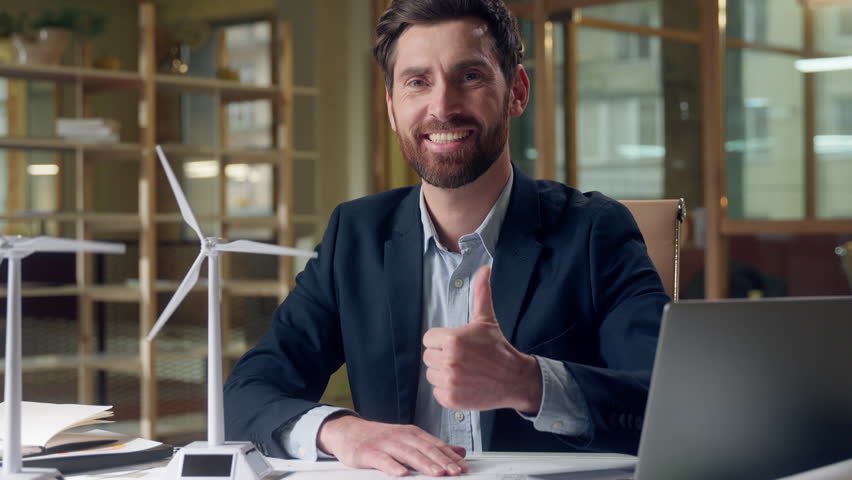 Happy Caucasian business man engineer windmill model working laptop showing thumb up gesture at office businessman male entrepreneur computer recommend approve renewable resources ecology green energy