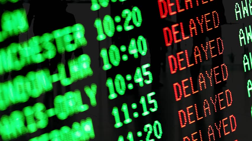 Flights delayed and canceled on departure board, flight delay footage. Device screen with airport flight information.