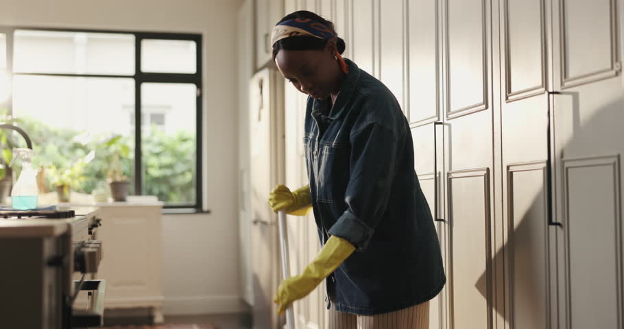 Broom, sweep and black woman in home for cleaning, floor maintenance and hygiene in kitchen. Housework, apartment and person with dirt for housekeeping, dust removal and prevention for chores