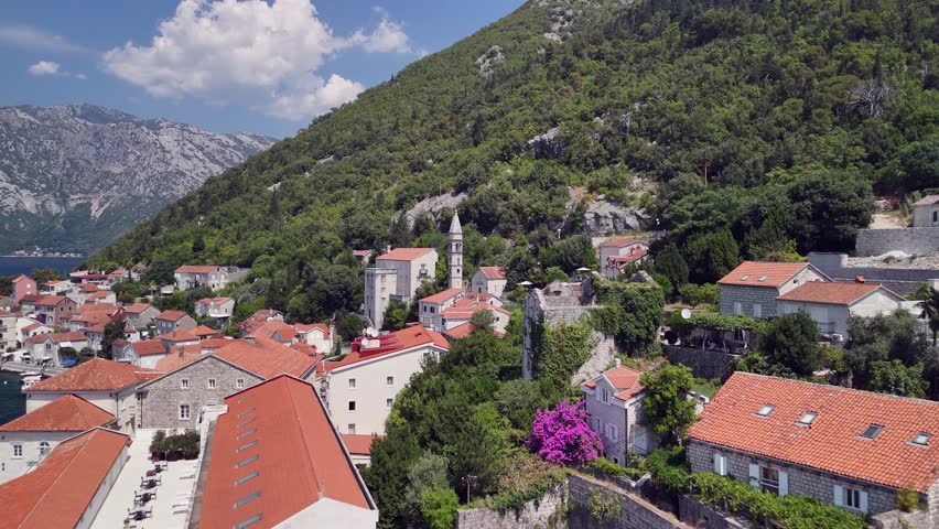 Flyover quaint hillside coastal town rooftops of Perast, Montenegro