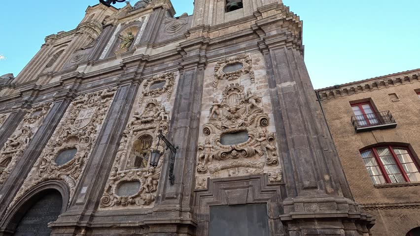 Baroque façade of the Church of San Felipe and Santiago el Menor in Zaragoza with intricate stucco decorations and sculptures under a clear sky