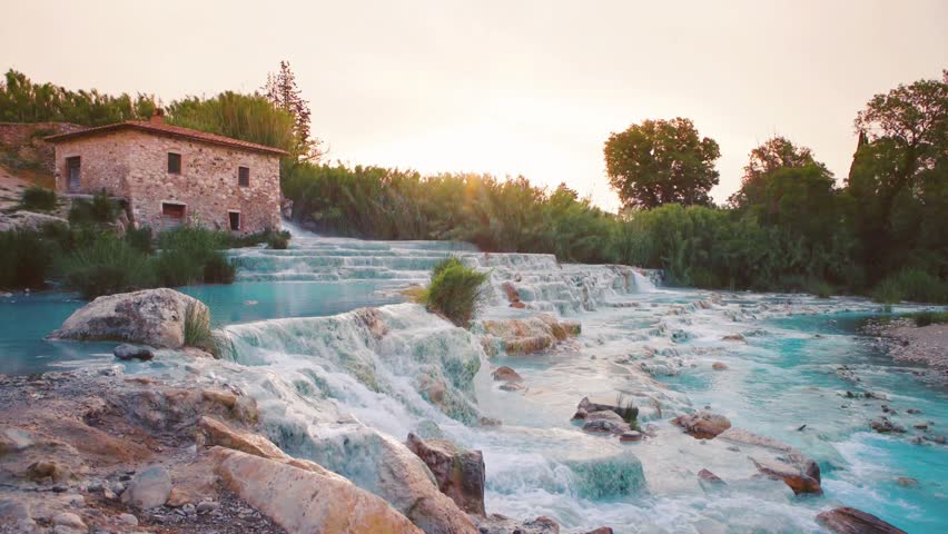 Saturnia hot springs at sunrise with rising steam, turquoise cascade pools in Tuscany. Cinemagraph.