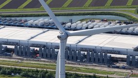 Aerial view of a wind turbine in front of a data center in the Eemshaven, clean energy, energy efficiency, and digital infrastructure - Powered by Shutterstock - Get 15% off with code: PIKWIZARD15
